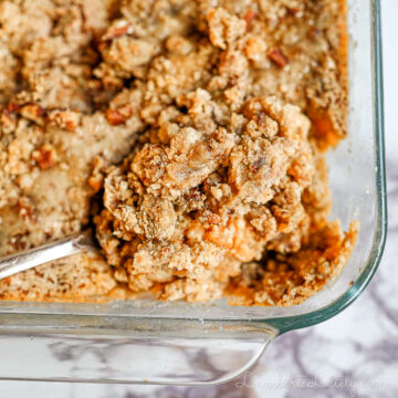 spoon in a baking dish of sweet potato casserole.