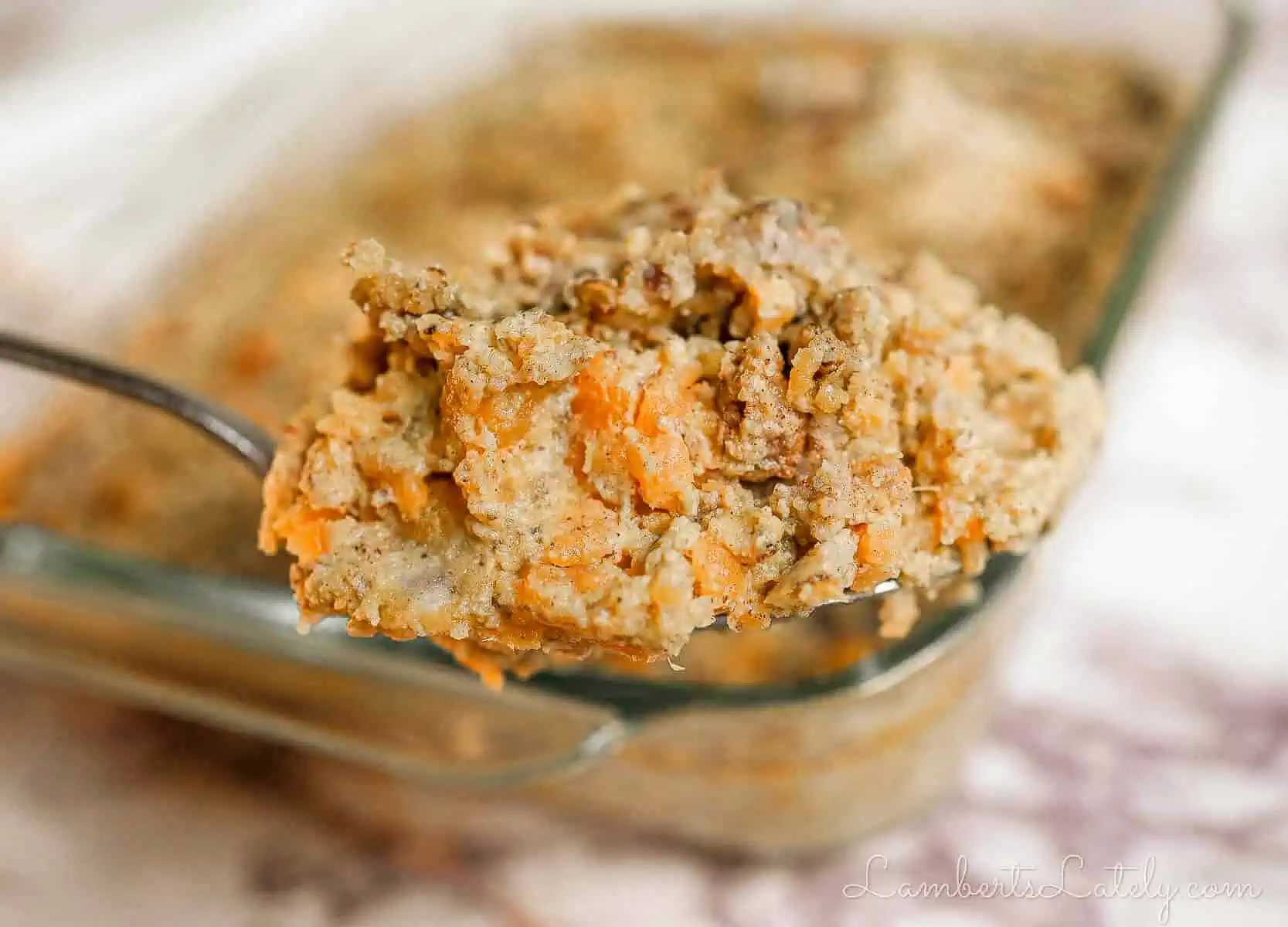 spoonful of creamy sweet potato casserole with pecan crumble topping.