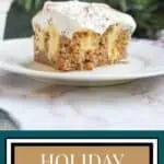 Close-up of a slice of eggnog poke cake with creamy frosting on a white plate.