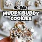 Muddy Buddy Cookies on a baking sheet with a hand holding one cookie in the foreground.