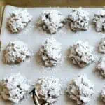 No-bake puppy chow cookies with chocolate, peanut butter, and marshmallows on a baking sheet.