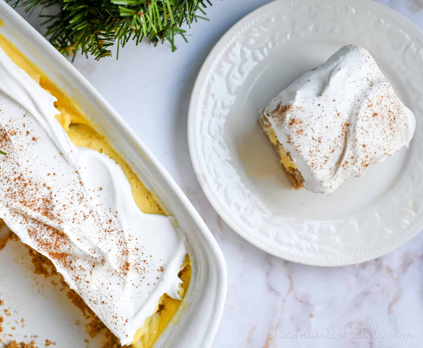 a piece of eggnog poke cake on a plate, next to a baking dish of cake.