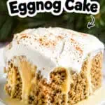 Close-up of a slice of Eggnog Poke Cake with creamy frosting and cinnamon topping.
