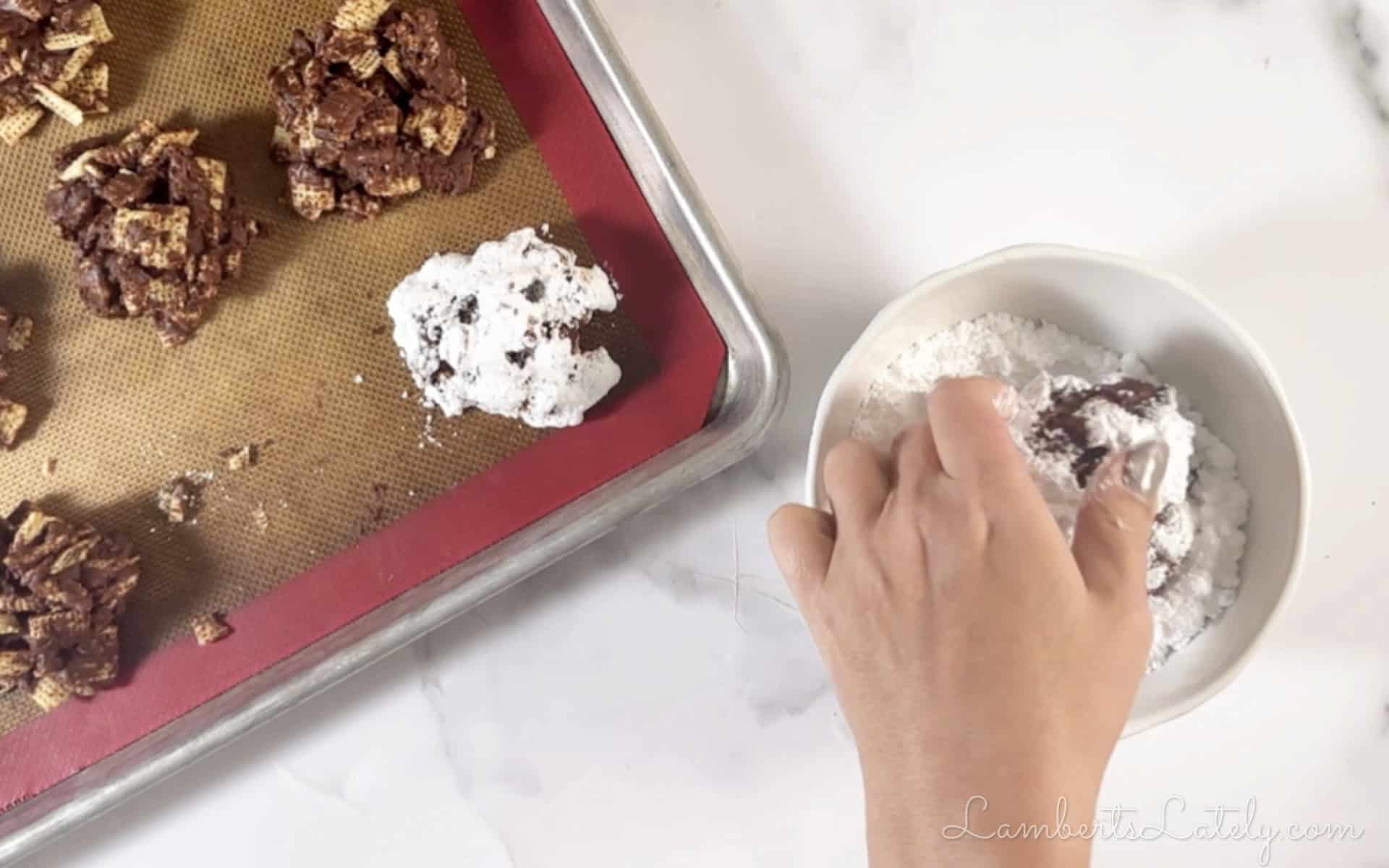 rolling formed cookies in powdered sugar.