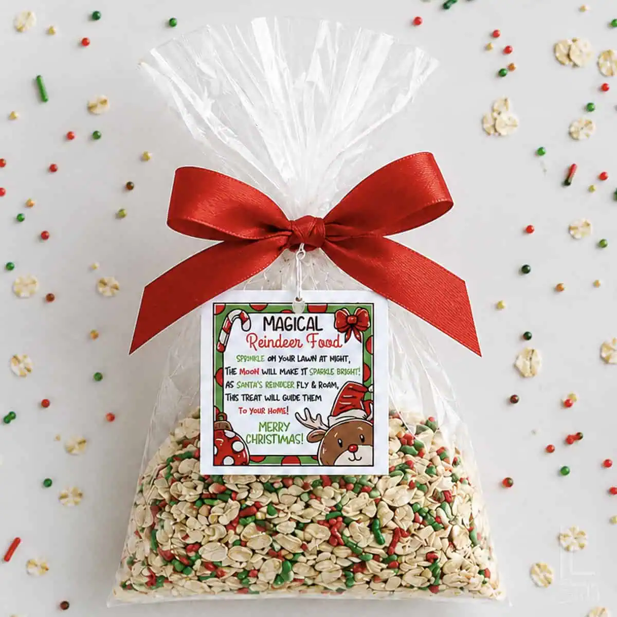 Reindeer food mix with sprinkles in a clear bag tied with a red ribbon for Christmas.