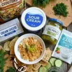 Close-up of ingredients for fried pickle dip with sour cream and dill pickles.