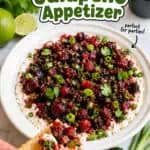 Cranberry jalapeño appetizer with fresh herbs and lime on a white plate.