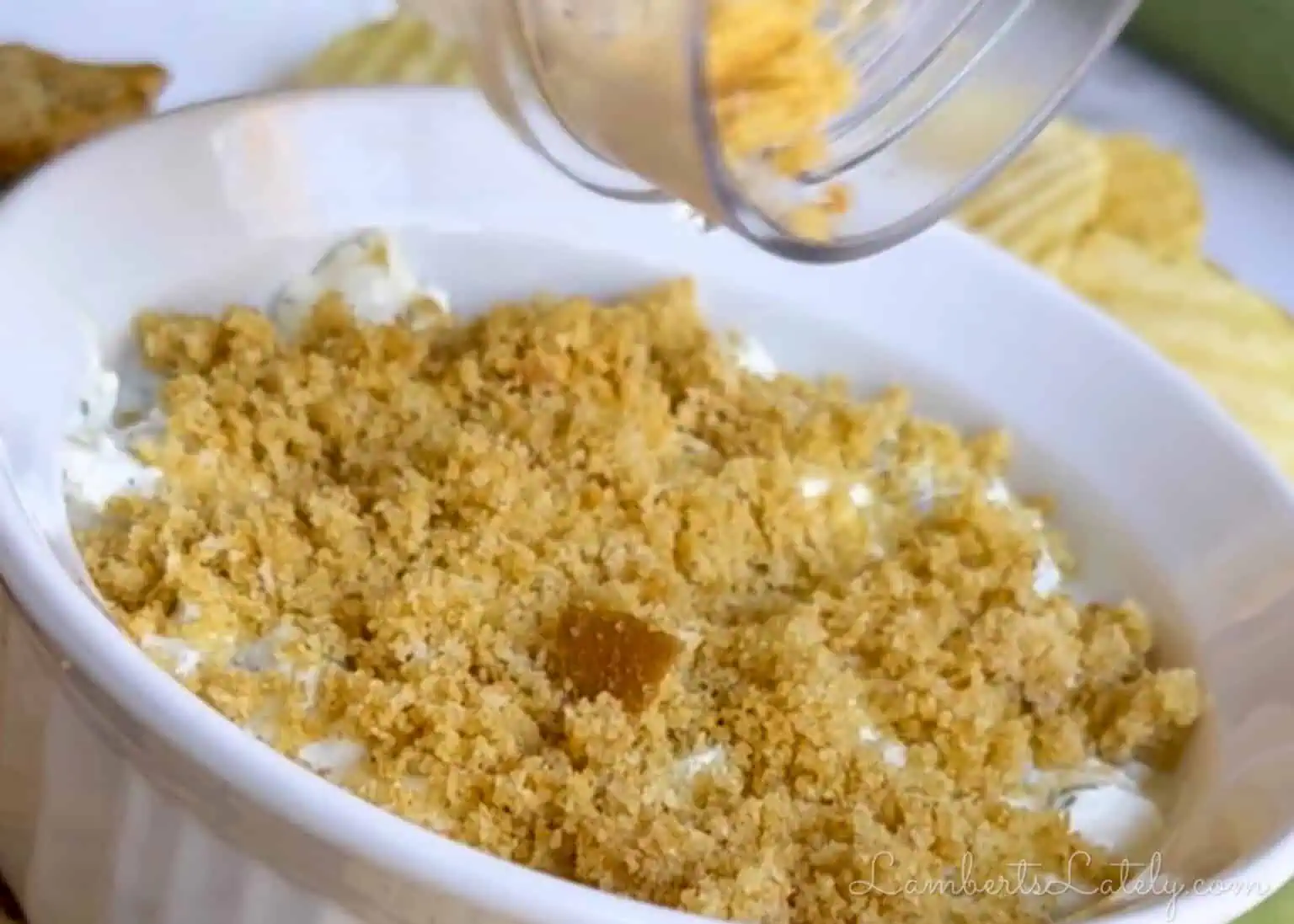 pouring breadcrumbs over the dill pickle dip.