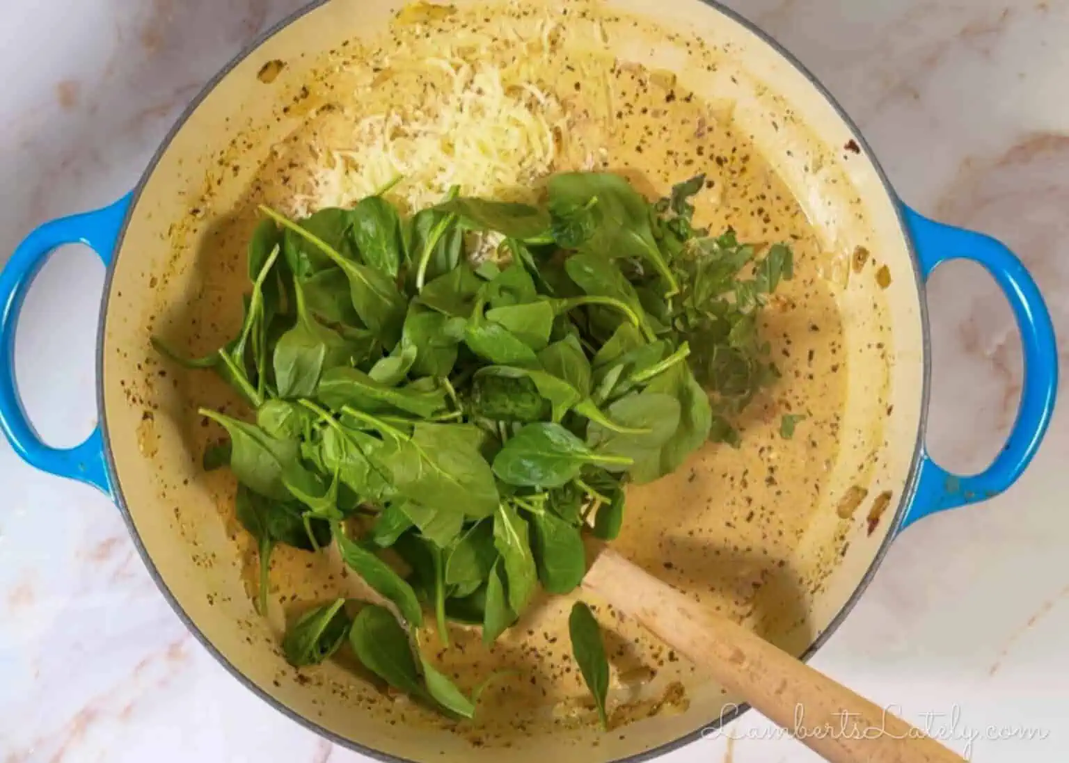 adding cheese, basil, and spinach to the soup.