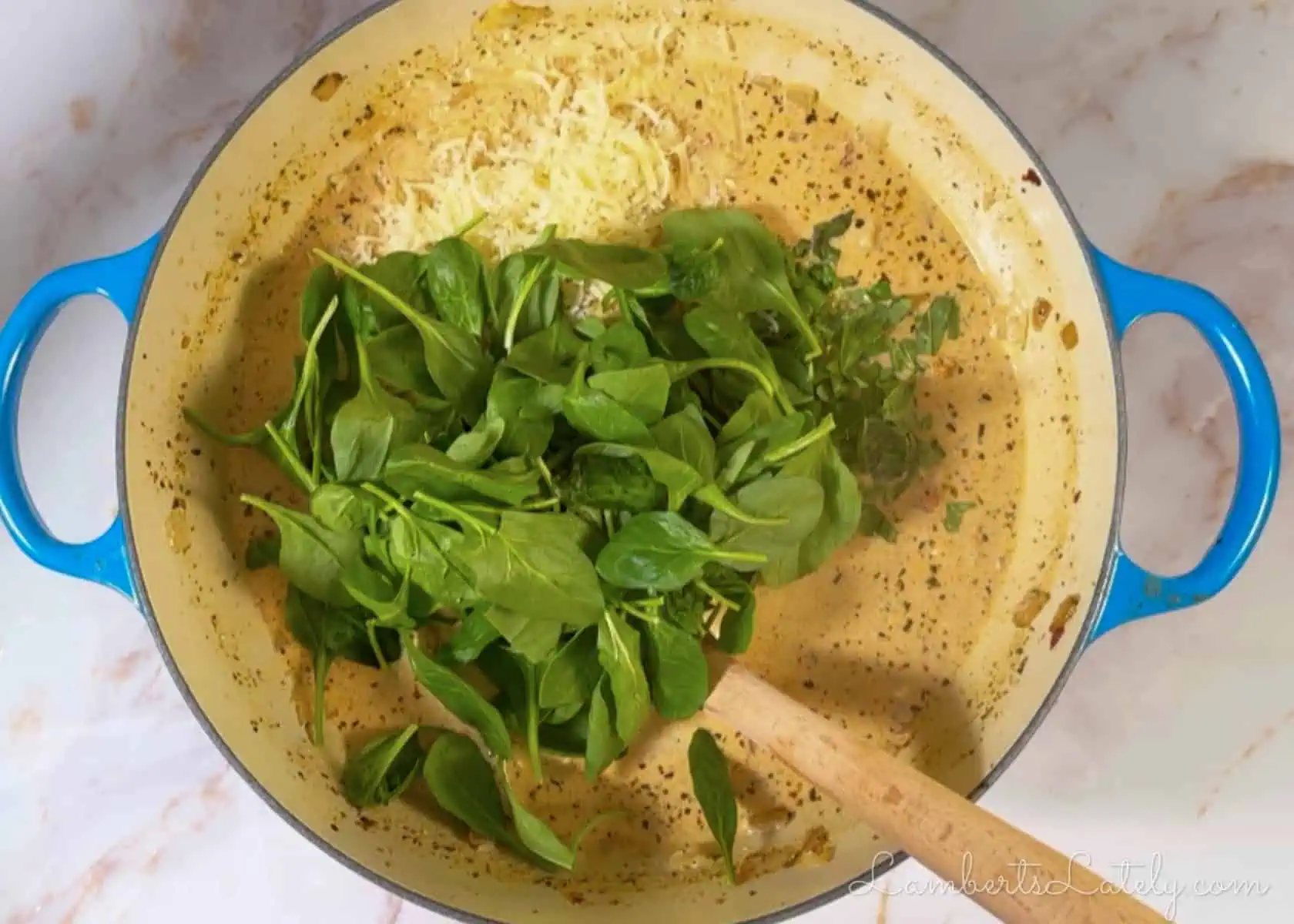 adding cheese, basil, and spinach to the soup.