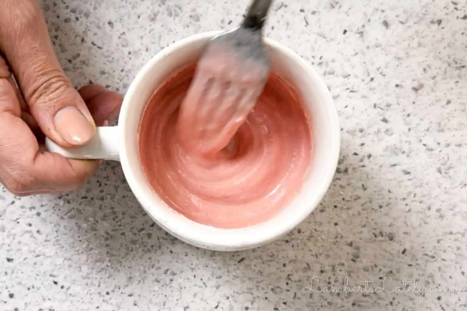 stirring the ingredients for 3-ingredient mug cake together in a mug.