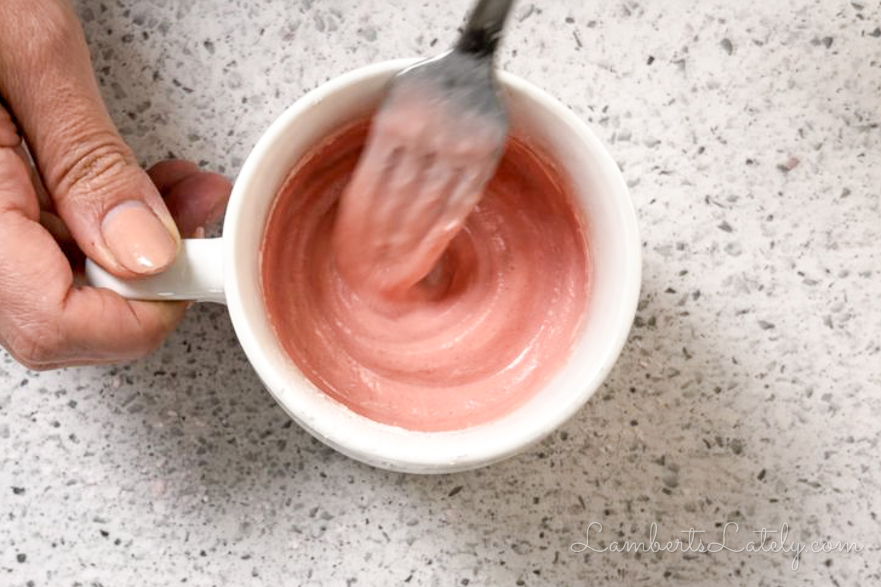 stirring the ingredients for 3-ingredient mug cake together in a mug.