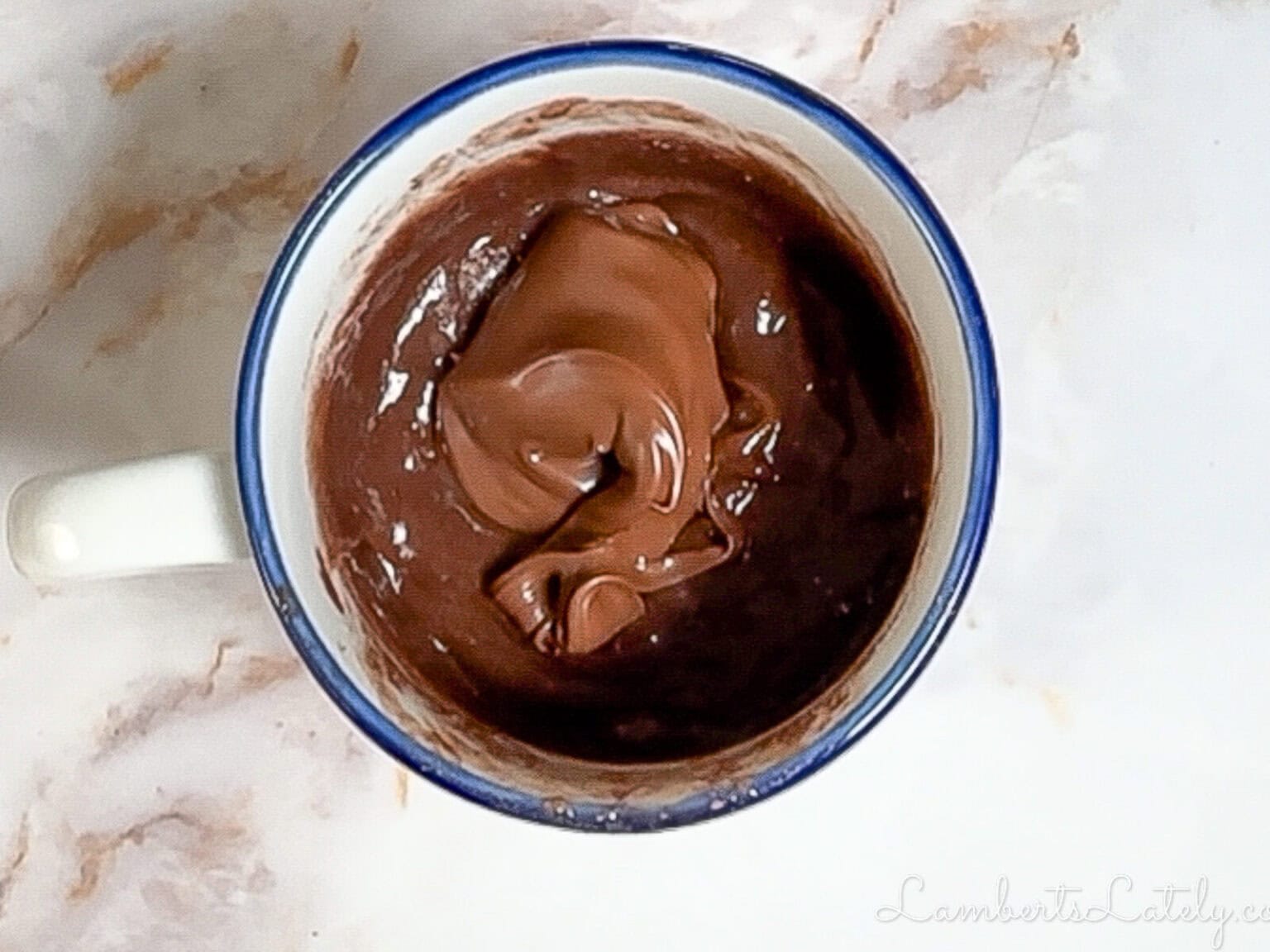 added a tablespoon of nutella to uncooked mug cake batter.
