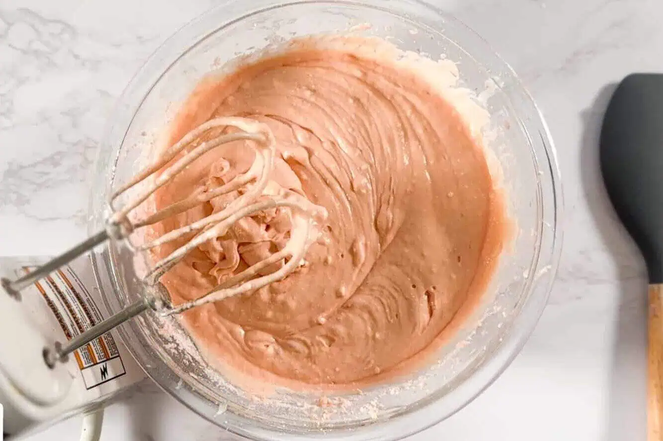 mixing strawberry cake mix in a bowl.