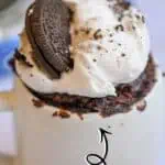 Delicious Oreo mug cake topped with whipped cream and an Oreo cookie.