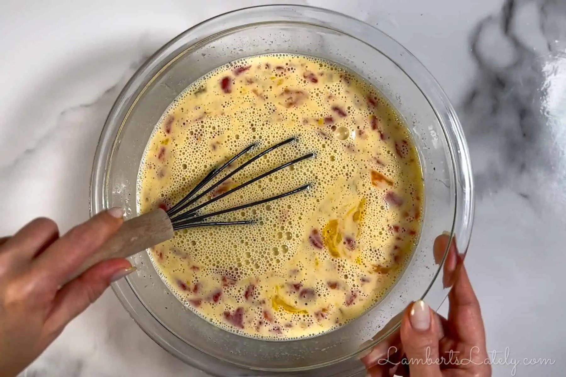stirring eggs, tomatoes, and seasonings in a bowl.
