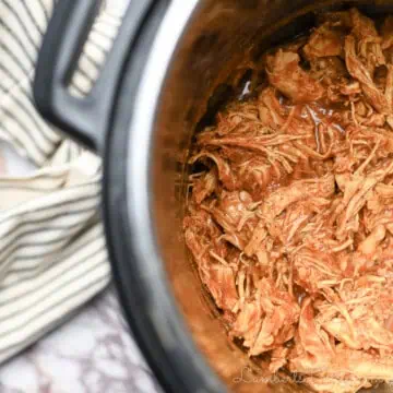 barbecue chicken covered in sauce in an instant pot, towel beside it.
