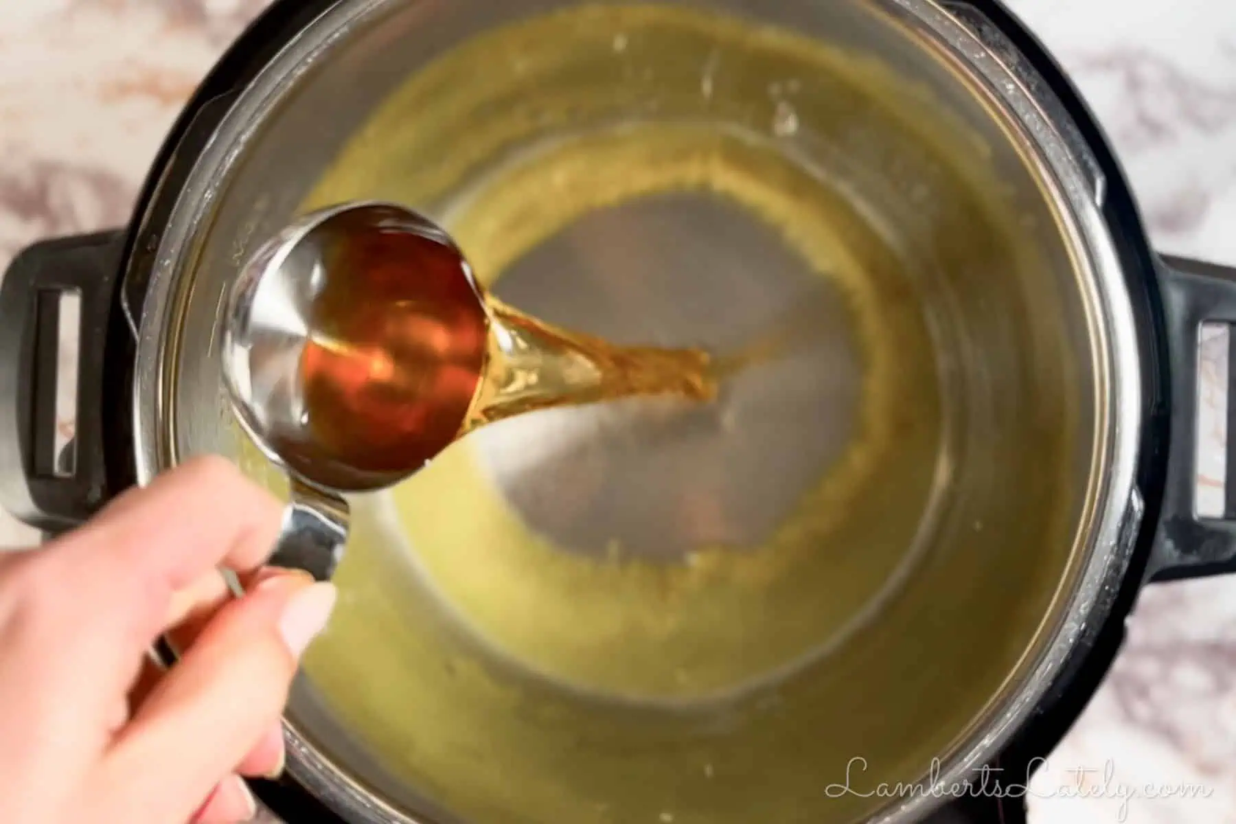 pouring apple cider vinegar in an instant pot.