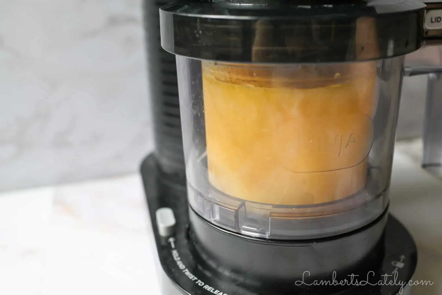 ninja-creami-mango-sorbet-4 mango sorbet going through the sorbet cycle in a ninja creami machine.