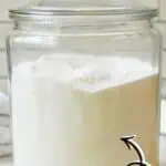 Homemade laundry detergent powder in a glass jar with label and scoop.