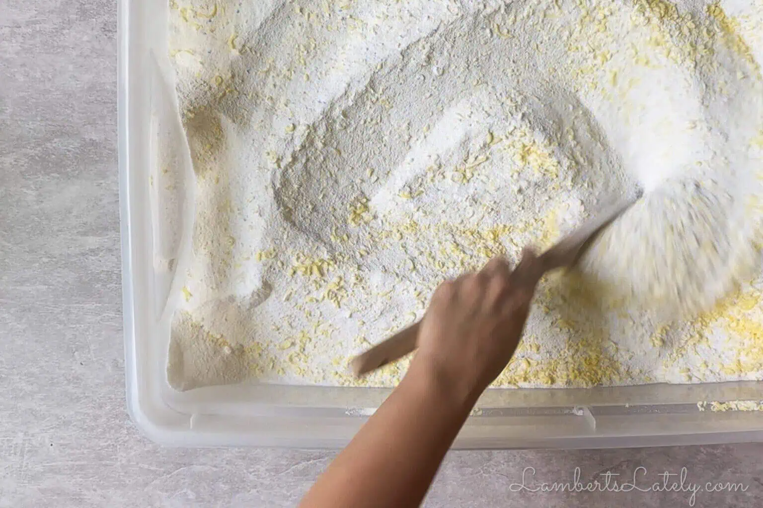 stirring diy laundry detergent together with a wooden spoon.