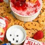 Close-up of strawberry pretzel fluff dip with strawberries and cookies around it.