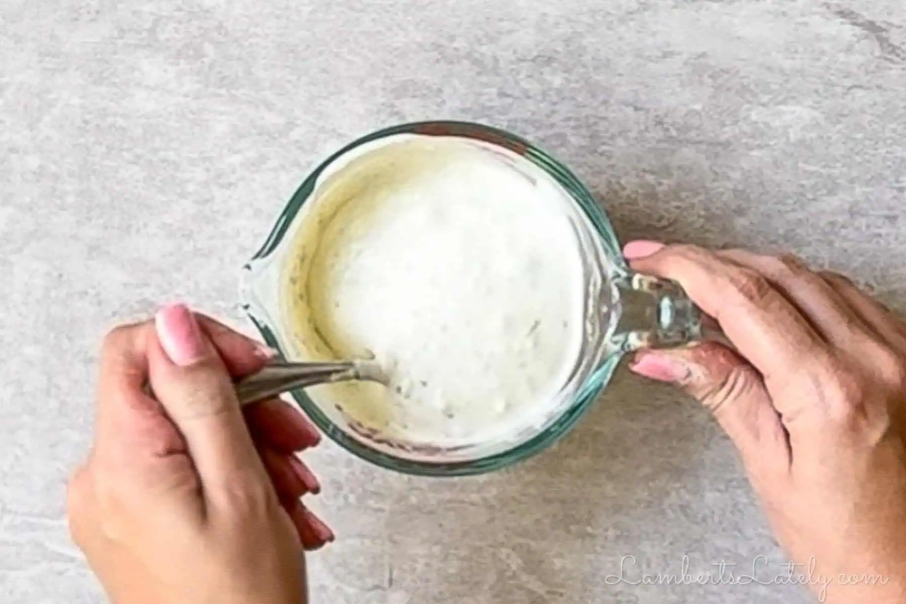 stirring ranch dressing for the salad in a measuring cup.
