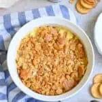 Baked Ritz chicken casserole with crackers, cheese, and creamy sauce in a white dish.