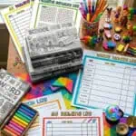 Colorful printable reading logs and school supplies on a desk for kids' reading tracking.