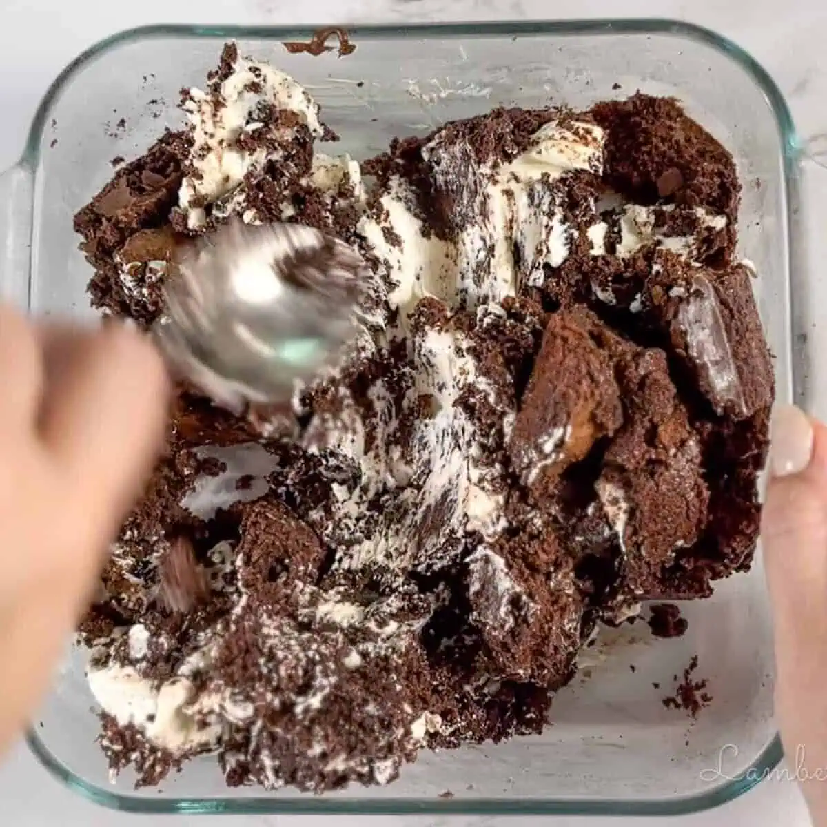 mixing cream cheese into crumbled brownies.