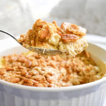holding a spoonful of ritz cracker chicken casserole above the baking dish.