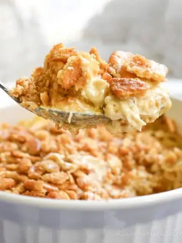 holding a spoonful of ritz cracker chicken casserole above the baking dish.