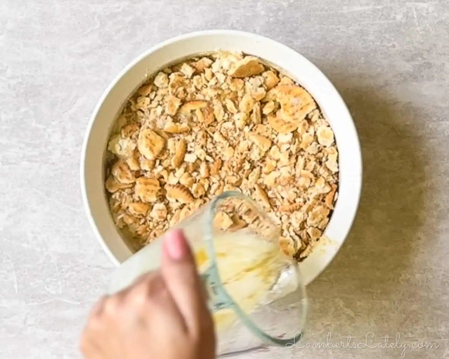 pouring melted butter over the crushed ritz crackers.