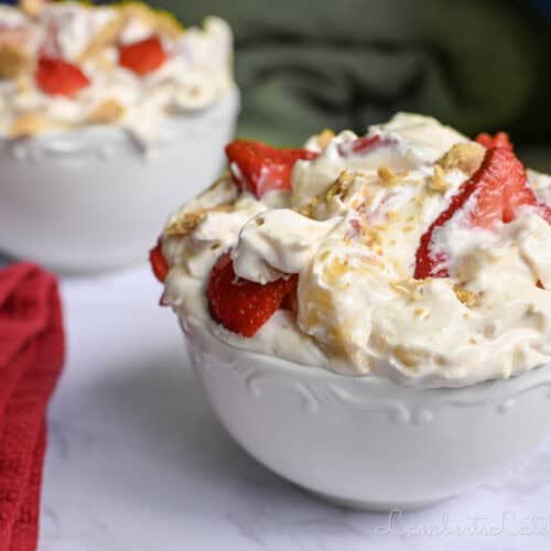 two bowls of strawberry banana cheesecake salad, next to a kitchen towel.