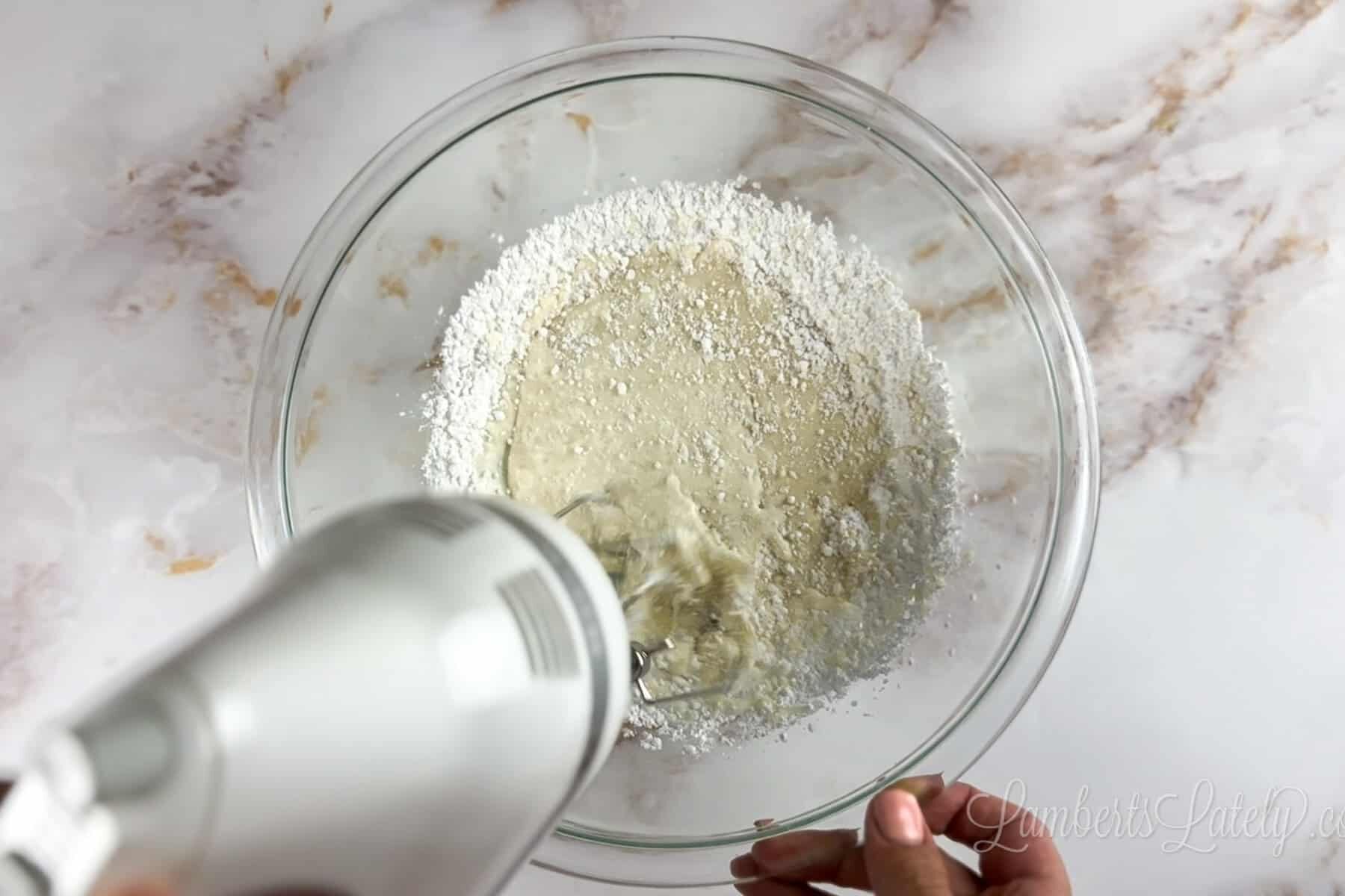 combining ingredients in a bowl with a mixer.