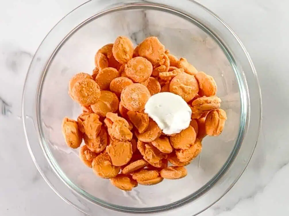 orange candy melts and crisco in a glass bowl.
