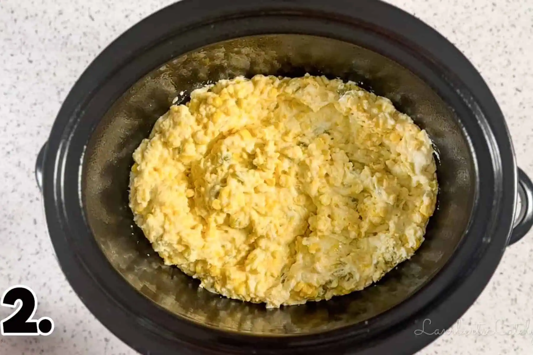 corn casserole mixture in a crock pot before cooking.