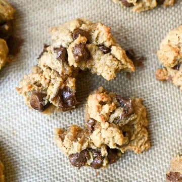 peanut butter chocolate chip cookie torn apart on a baking sheet.