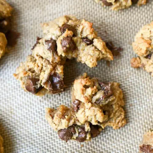 peanut butter chocolate chip cookie torn apart on a baking sheet.