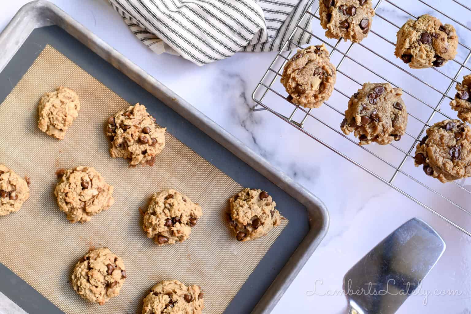 peanut butter chocolate chip cookies cooling on a baking rack, on a lined cookie sheet.