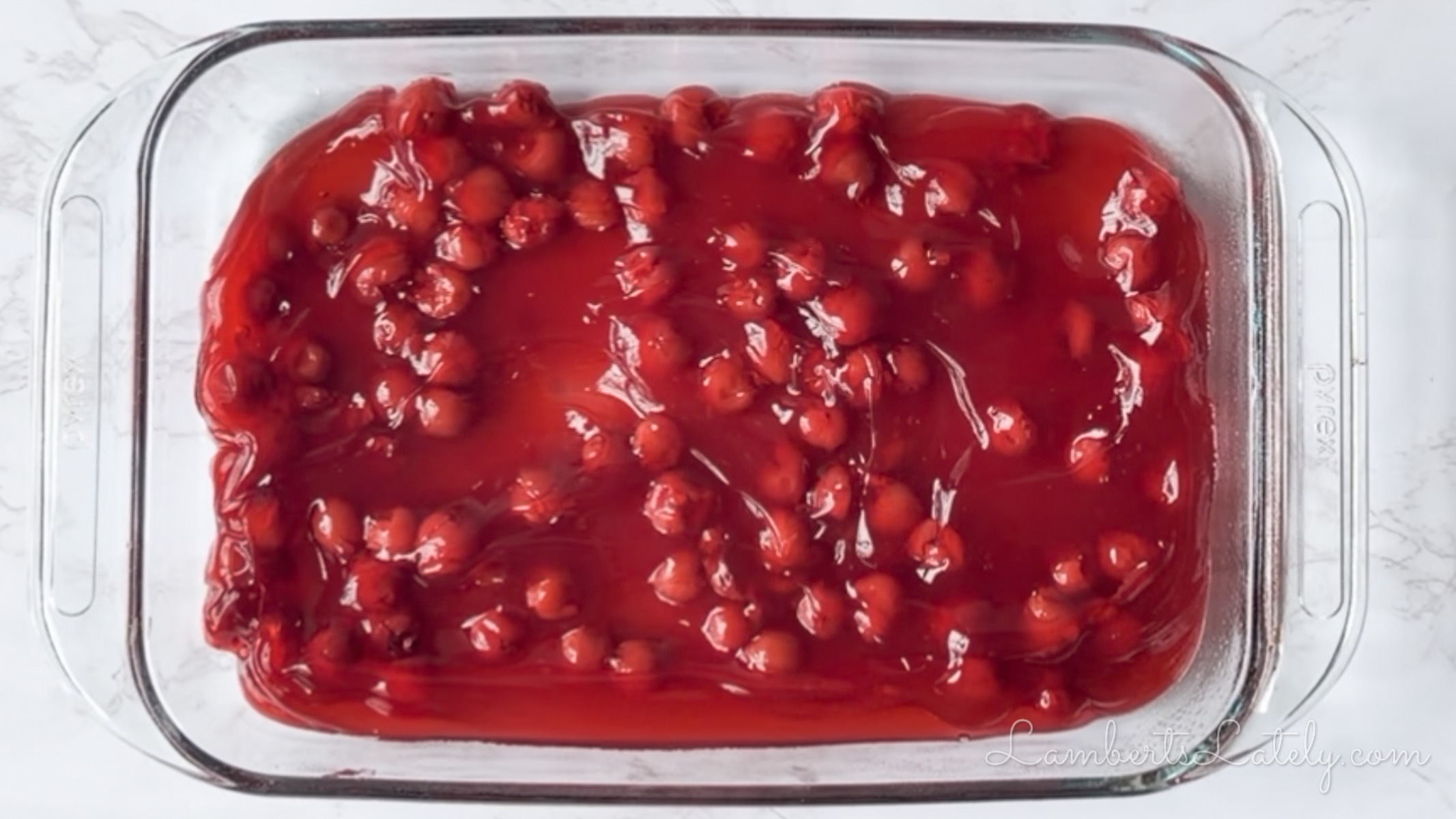 cherry pie filling in a pyrex baking dish.