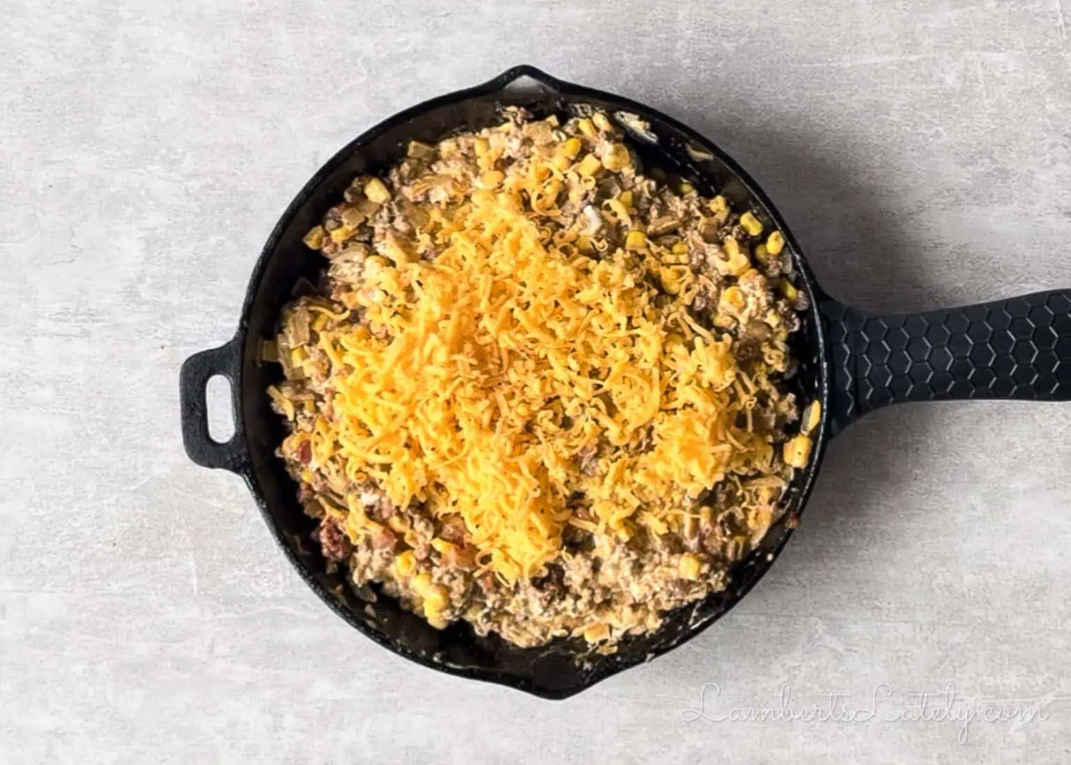 added cheese to the ground beef mixture in the cast iron skillet.