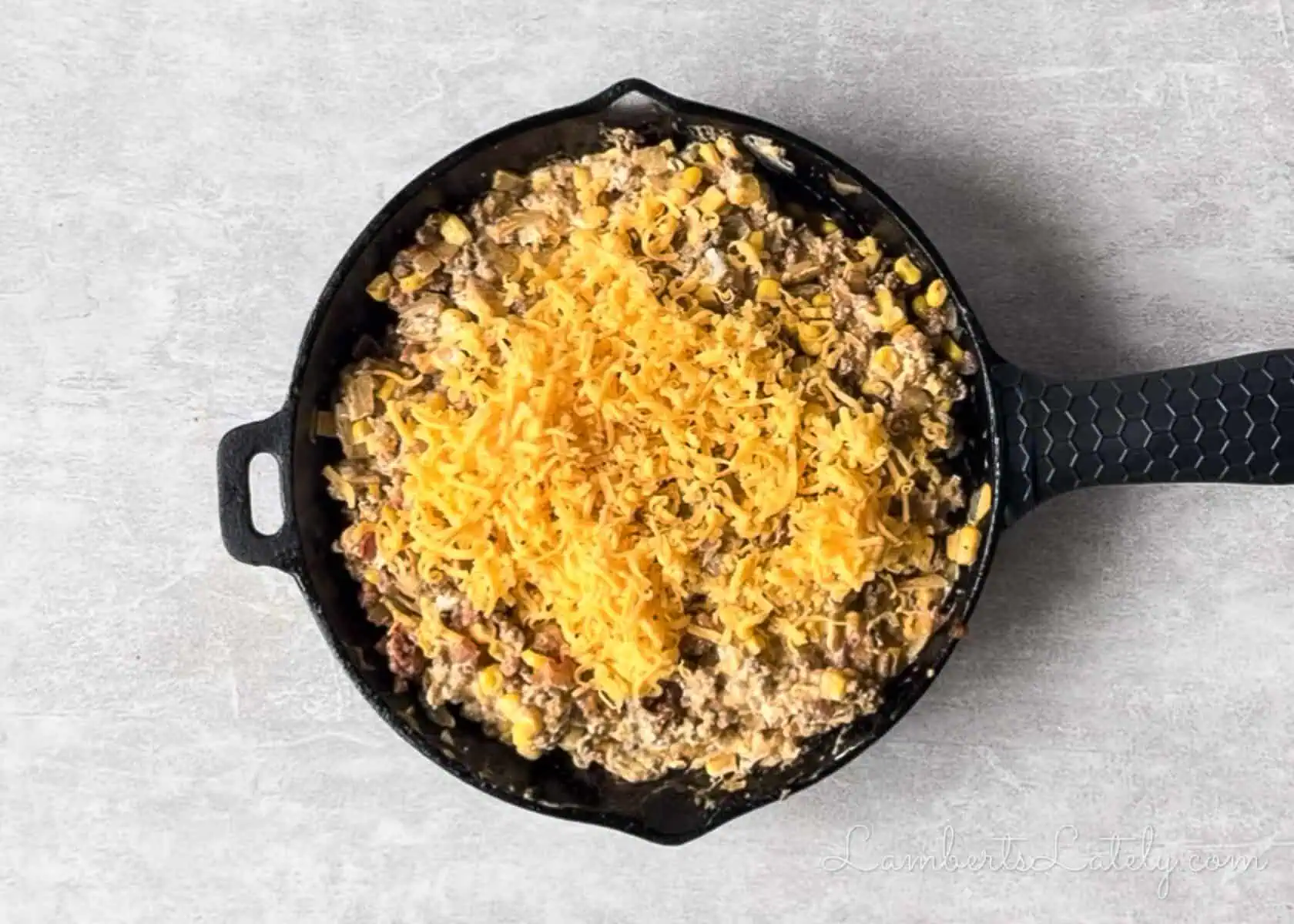 added cheese to the ground beef mixture in the cast iron skillet.