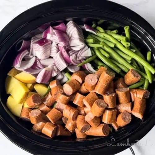 added sausage to the vegetables in the crock pot.