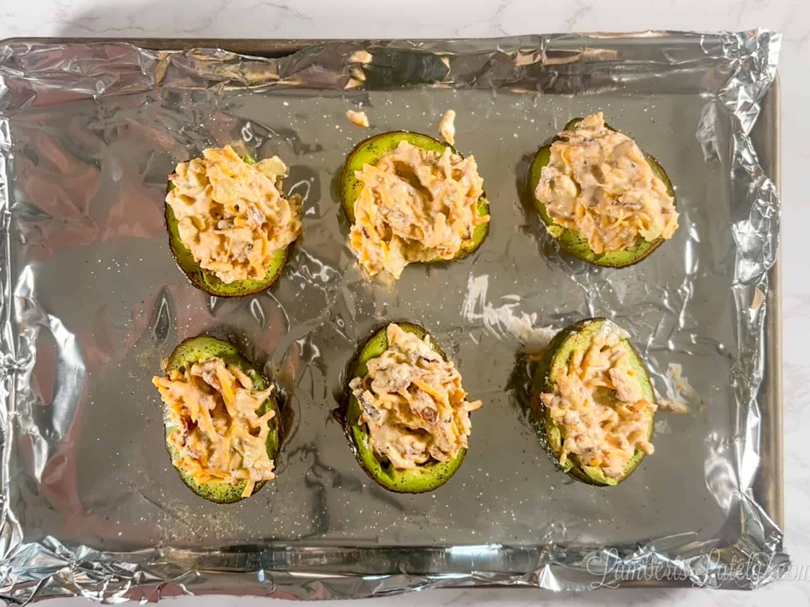 stuffed avocados on a baking sheet.