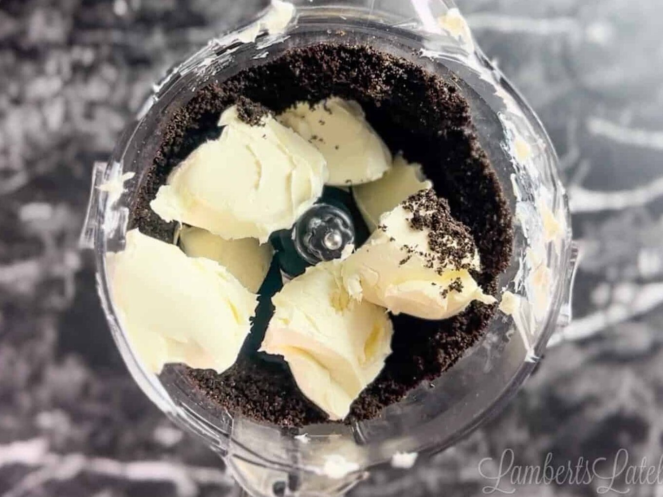 cream cheese on top of oreo crumbs in a food processor.