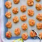 Party-perfect Rotel sausage balls on baking sheet with ingredients shown.