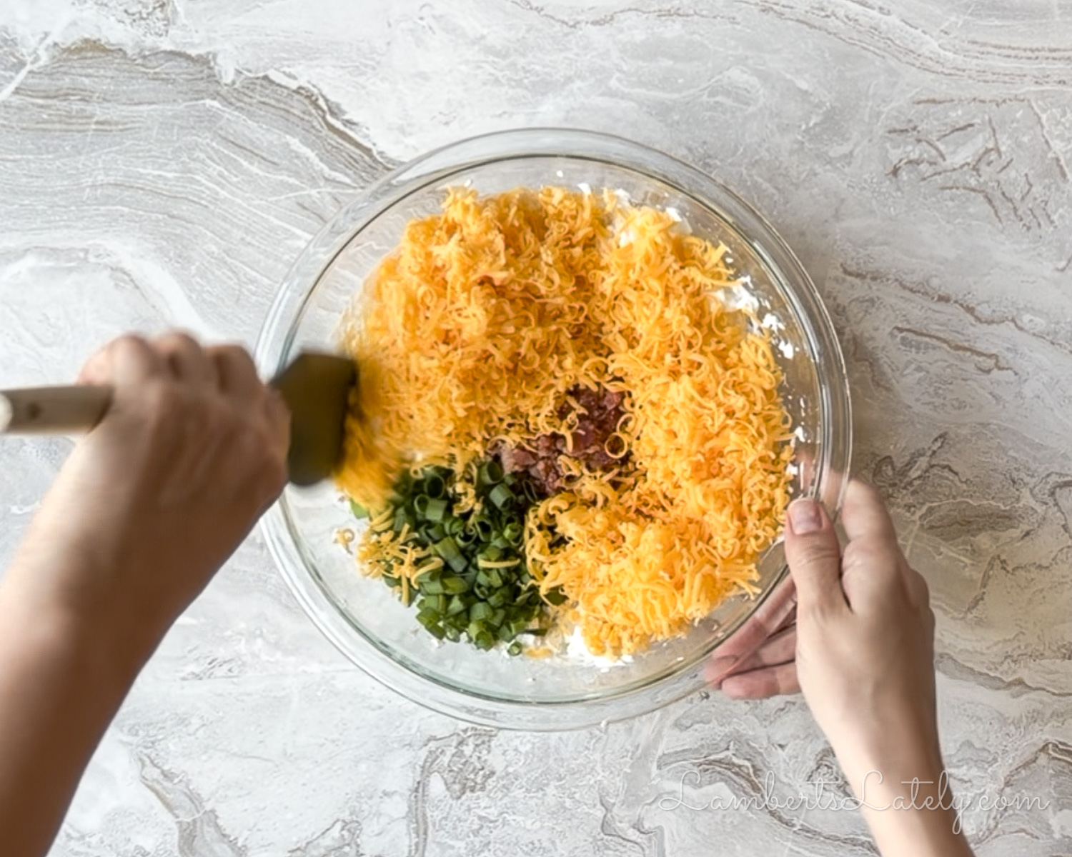 stirring cheese, bacon, and green onions into the cream cheese mixture.