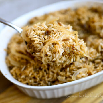 holding a spoonful of french onion rice in front of a casserole dish.
