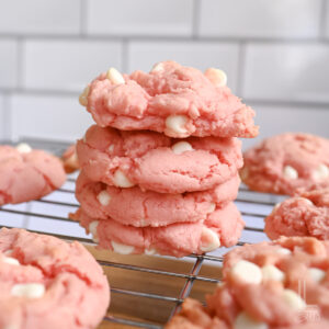 stack of strawberry cake mix cookies on a baking rack.